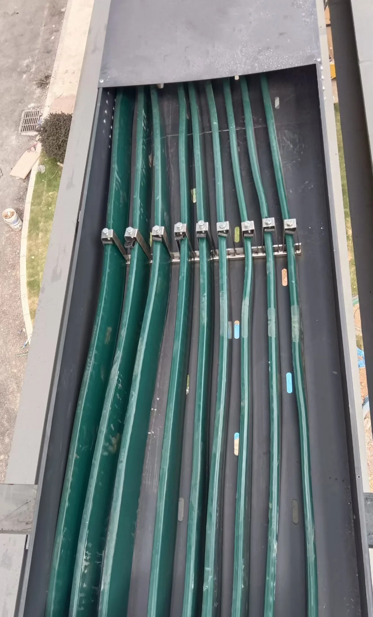 Phase cables clamped inside a duct, with the bends taken inside the run